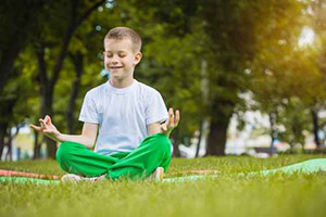happy kid is doing exercises in the park